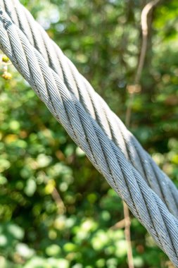 Twisted steel rope suspension bridge in nature close-up