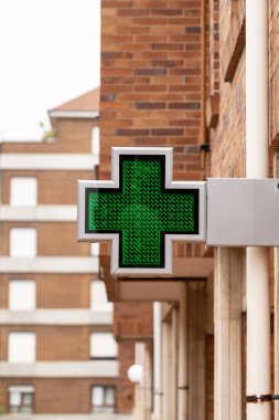 Hastane işareti. Acil yardım sembolü. Aydınlatılmış tabela. Şehir sokak manzarası. Eczane eczanesi. Yakın plan.