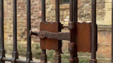 Kilitli bir ortaçağ kafes kapısının paslı demirli sürgüsü. Vintage eğimli retro tasarım