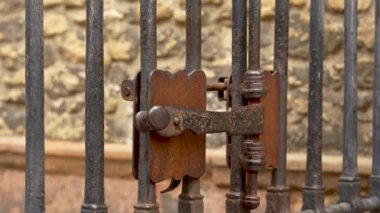 İspanya 'daki antik katedralin kafes kapısının kapalı kapısının eski metal işlemeli sürgülü sürgüsü (mandalı). Mekanik ortaçağ kilidi