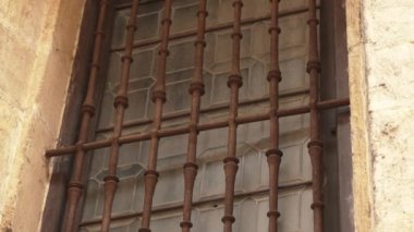 Bina penceresinin yakın plan kahverengi paslı güvenlik ızgarası (kafes). Koruma için mimari dekorasyon