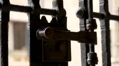 Antika katedralin İspanya 'daki kafes kapısının kilidini kilitleyen sürgülü paslı antik metal kilit. Eski moda tasarım. Dramatik koyu görünüm