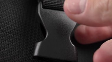 Closing black plastic clasp on nylon backpack straps close-up