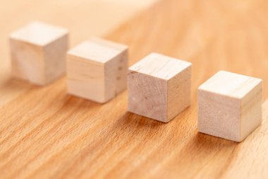 Wooden cubes in a row on a wood background. Toy blocks close-up. Blank for the concept