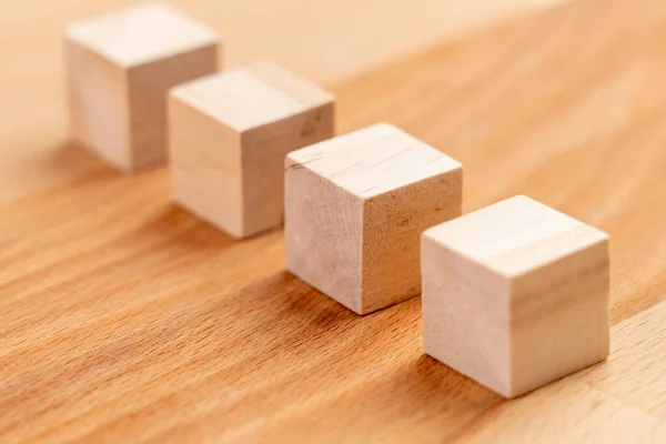 Wooden toy blocks. Geometric wood cubes in a row. Teamwork and management concept. Business strategy idea. Conceptual blank