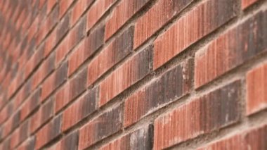 Brick red wall with uneven texture. Exterior decorative rough surface of the facade of the building. Close-up