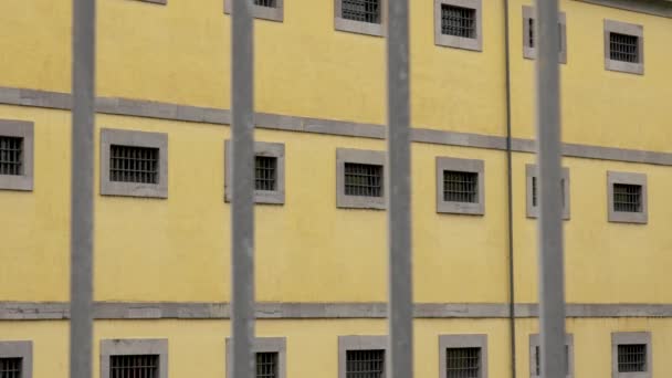 Metal Fence Spikes Old Historical Prison Building Barred Windows Yellow — 图库视频影像