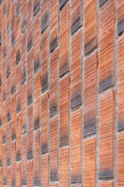 Rough wall of red brown bricks close-up. Vertical masonry
