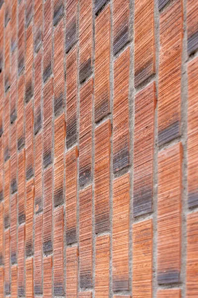 Rough wall of red brown bricks close-up. Vertical masonry