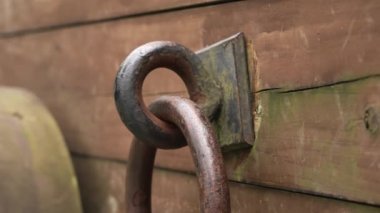 Iron rusty ring of a wooden cracked cart platform of a medieval artillery cannon close up
