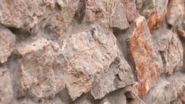 Kaba dokusu ve pürüzlü yüzeyi olan doğal taş duvar.