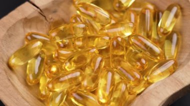 Omega 3 balık yağı kapsülleri ahşap kırsal kasede. Döndürme