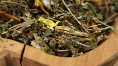 Kuru Çin Çiçeği çayı ve ahşap bir kapta kurumuş kokulu yapraklar. Döndürme