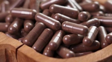 Vejetaryen geleneksel ilaç kapsülleri. Beslenme takviyesi. Kırsal bir kasedeki doğal haplar. Döndürme