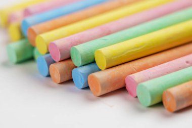 Çok renkli pastel tebeşirler beyaz kağıt üzerine yığılmış bir yığın. Renkli koleksiyon. Makro atış. Okul ve anaokulu yaratıcılığı için malzeme