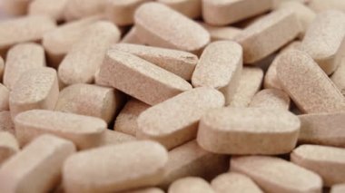 C vitamini hapları yakın çekim. Bir yığın bej eczacılık hapı. Makro atış. Döndürme