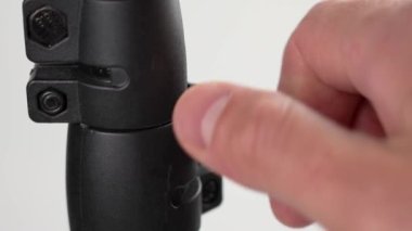 Siyah bir fotoğraf tripodunu eliyle sıkıca bağlamak. Stüdyo ekipmanları kuruluyor.