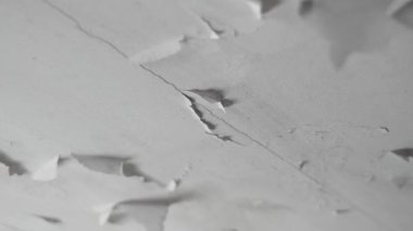 Banyonun tavanında beyaz boya tabakası çatlamış. Yüksek nem ve su sızıntısından sonra hasarlı alçıpan