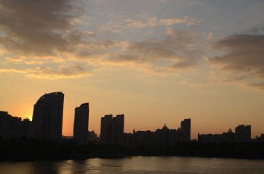 Günbatımı gökyüzü köprüden görünen binalar ve nehirler üzerinde