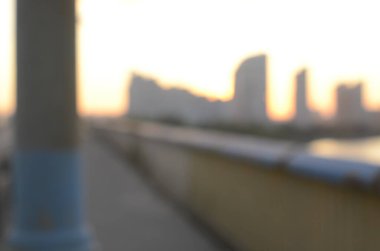 Köprü ve günbatımı görüntüsü çözüldü. Nehir üzerinde binalar var.