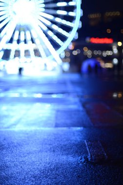 Dönme dolabın odaklanmamış görüntüsü sokak sahnesinde aydınlatıldı 