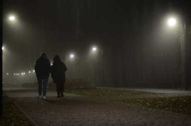Yürüyen insanlarla aydınlatılmış gece manzarası