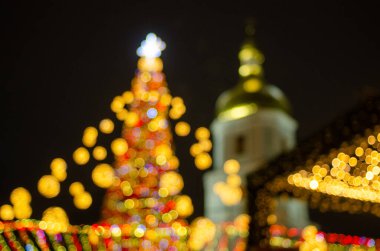 night shot of festive lights at Christmas fair and bell tower