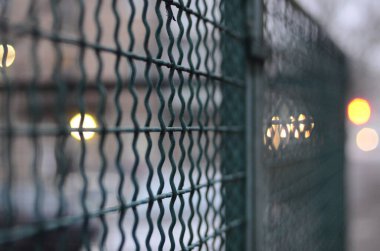 Bokeh ışıkları ve metal çitlerle soyut arkaplan