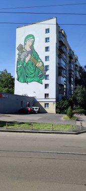 Ukrayna şehrinin duvarında silahlı bir kadının duvar yazısı görülüyor.