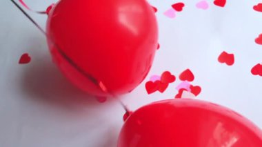 Beyaz arkaplanda kalp şeklinde kırmızı balonlar.
