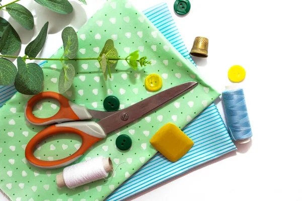 缝制饰物 蓝色和绿色面料 白色背景 纽扣和缝纫厘米 — 图库照片
