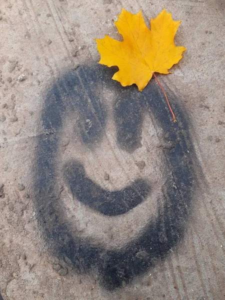 Χαμογελαστό Πρόσωπο Άσφαλτο Κίτρινο Φύλλο Σφενδάμου — Φωτογραφία Αρχείου