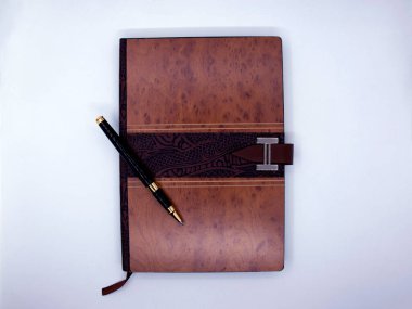 Beyaz arkaplanda tükenmez kalemle yakın plan bir not defteri..