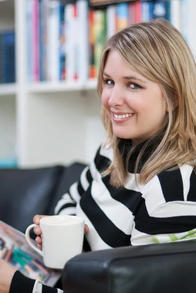 Jonge vrouwen met een koffiekopje in haar hand — Stockfoto