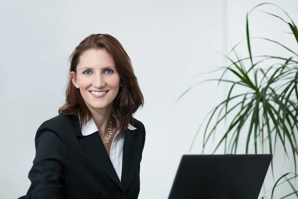 Aantrekkelijke zakenvrouw met laptop — Stockfoto