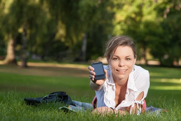 Jonge, aantrekkelijke vrouw toont haar smartphone — Stockfoto