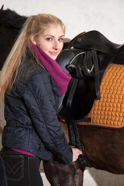 Menina sela seu cavalo — Fotografia de Stock