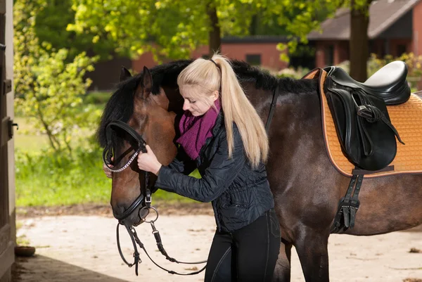 Girl bridles her horse — Stock Photo, Image