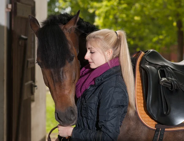 Menina olha para seu cavalo — Fotografia de Stock