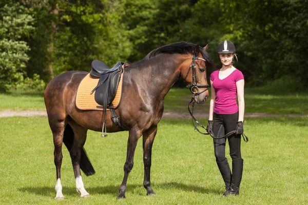 Girl stands besides her horse — Stock Photo, Image