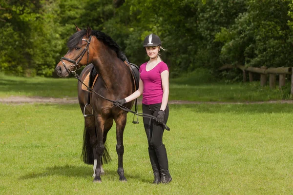 Chica de pie junto a su pony — Foto de Stock