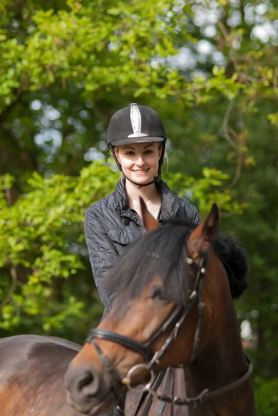 Chica se sienta en su pony — Foto de Stock