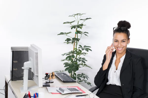 Jonge zakelijke vrouw telefoons aan de balie — Stockfoto