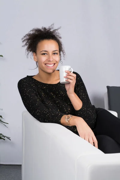 Mujer joven sostiene una taza de café — Foto de Stock