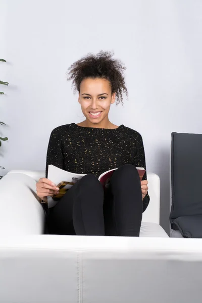Jonge vrouw leest een tijdschrift — Stockfoto