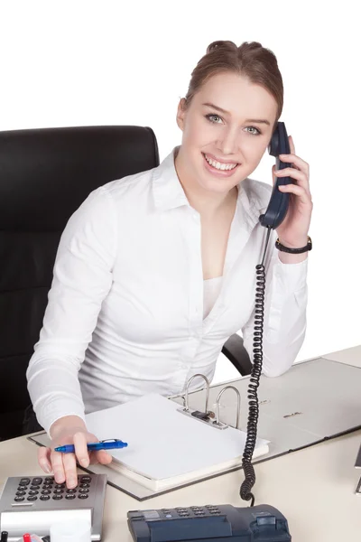 Ung kvinna telefoner vid skrivbordet — Stockfoto
