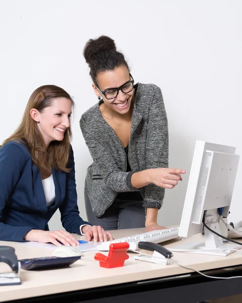 Dos mujeres frente a la computadora en la oficina — Foto de Stock