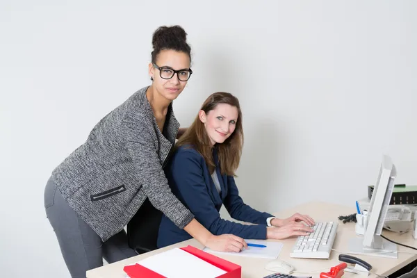 Two women at the desk in the office — Stock Photo, Image