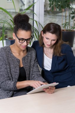 Woman is showing something at a tablet clipart