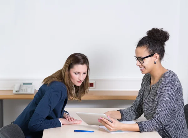 Woman is showing something at a tablet — Stock Photo, Image